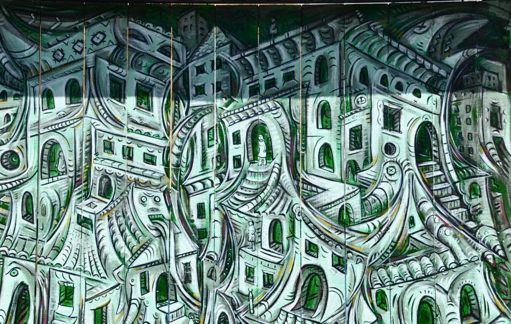 Graffiti of green housing overlapping each other.