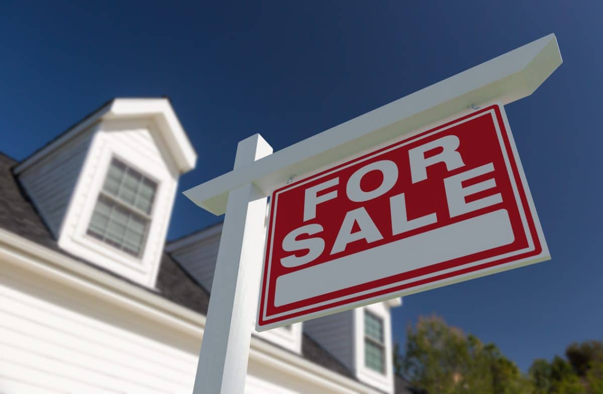 For Sale Real Estate Sign in Front of New House.