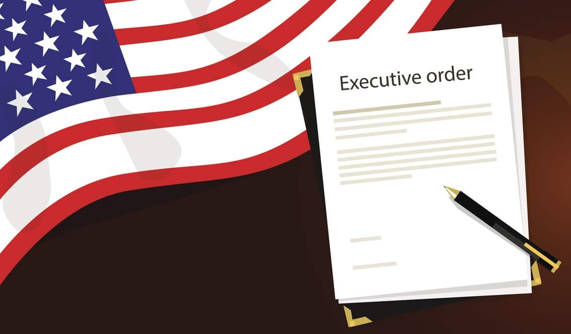 Illustration with portion of waving American flag at top left, a paper in a portfolio headed "Executive order" in the center, and a pen resting on the paper. Background is a brown map of the world, mostly covered, but with North America faintly visible.