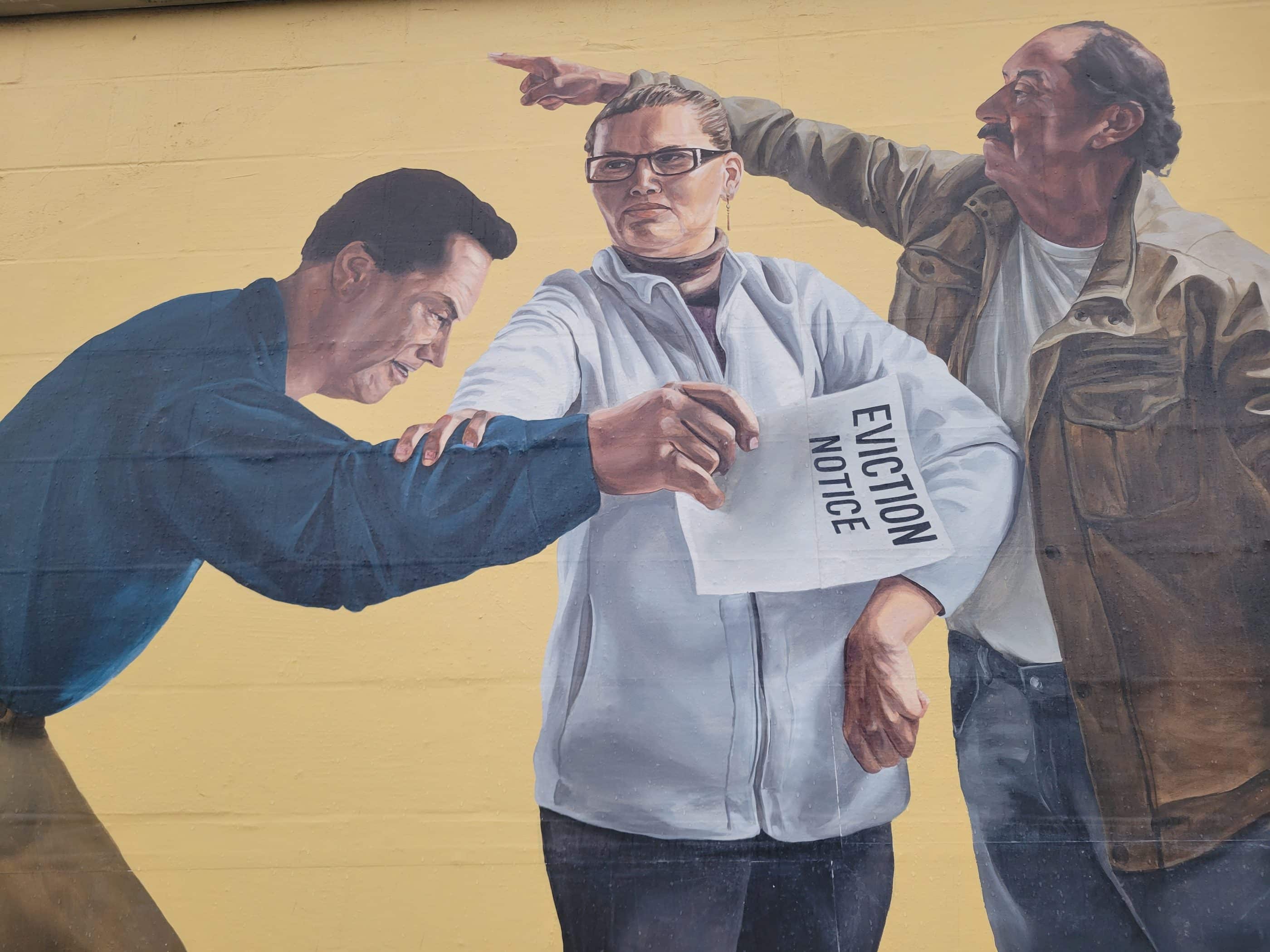 A painting of three people. One is pointing. Another holds a paper that says "eviction notice." They appear determined.