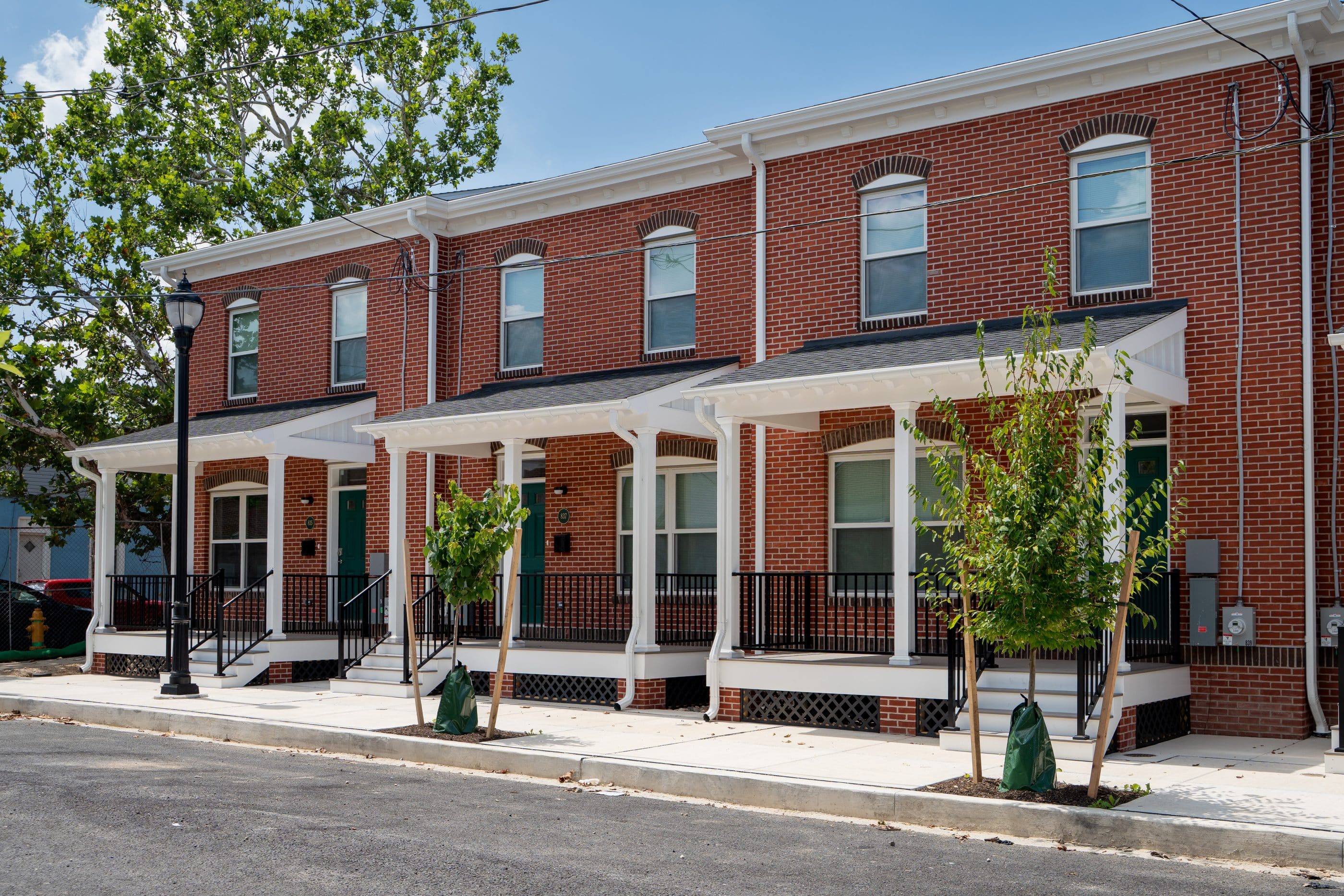 Three attached two-story brick homes with white awning