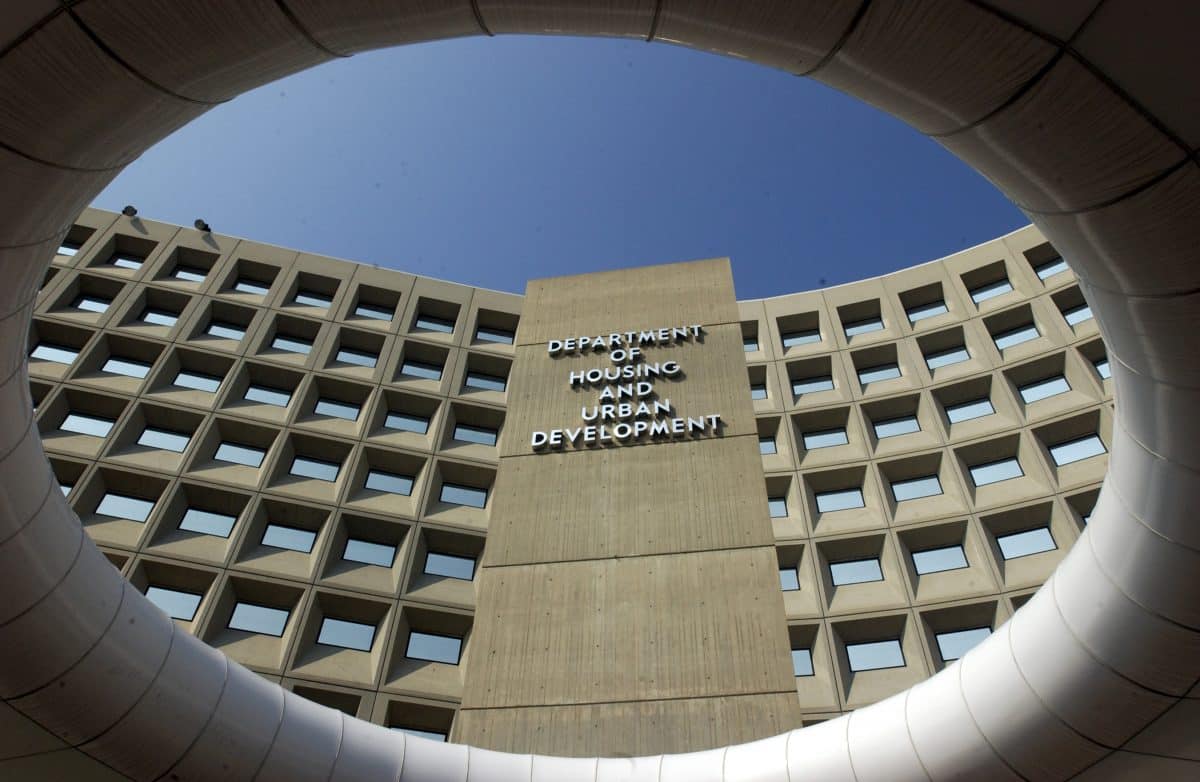 The front of a large concrete building with many exterior windows. Large capital letters on the top of the building read DEPARTMENT OF HOUSING AND URBAN DEVELOPMENT.