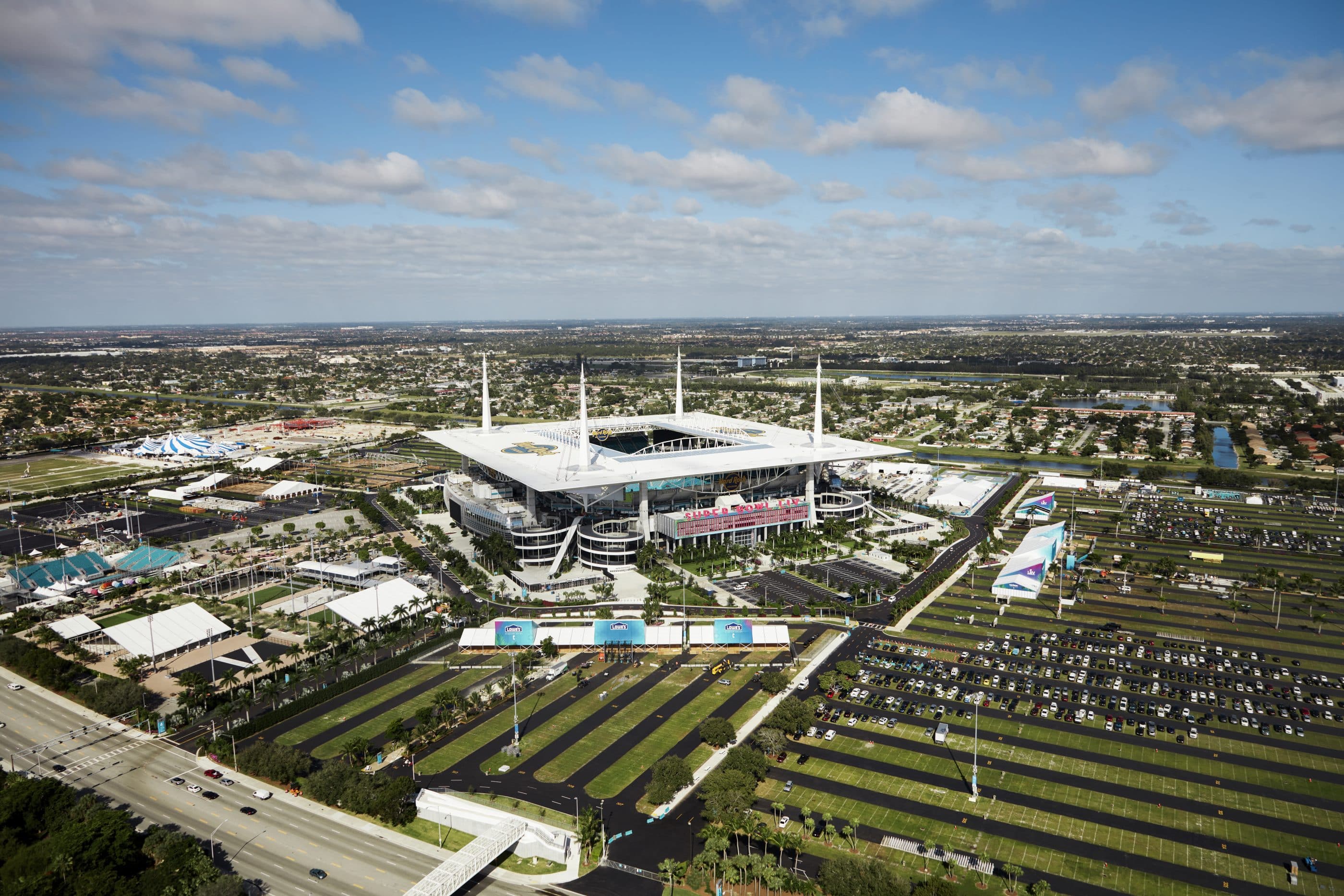 A stadium viewed from above, surrounded by sprawling fields and parking.